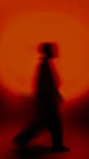 Blurred figure walking through orange light